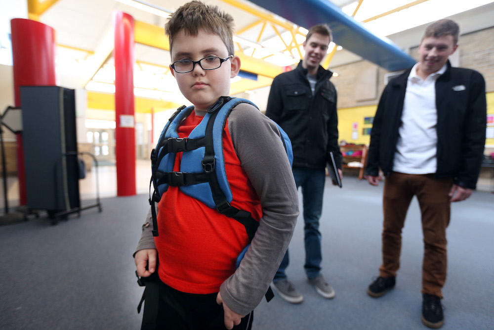 Liam Craig tried on a backpack designed for children on the autism spectrum by University of Minnesota students Will Radke left and Jake Portra March 3, 2016 in Woodbury, MN. ] Jerry Holt/Jerry.Holt@Startribune.com