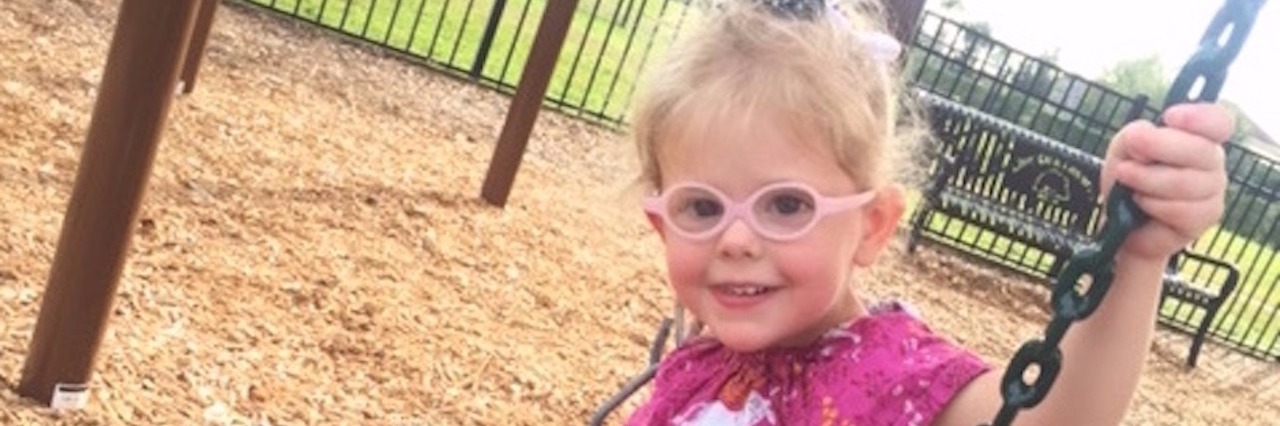Losing Business From Customers as a Special Needs Parent little girl in glasses on a swing