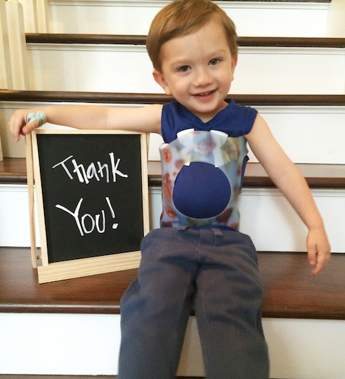 little boy on stairs holding thank you sign