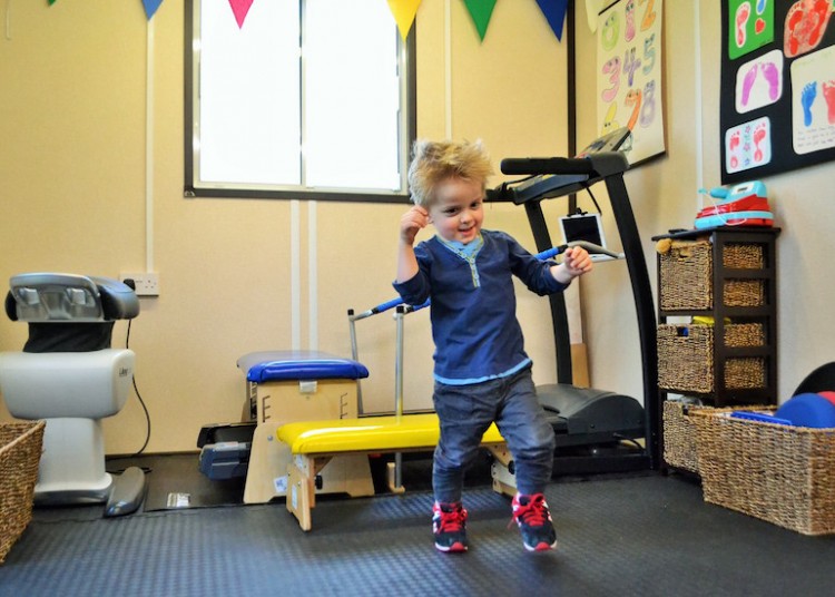 young boy learning to walk in his gym