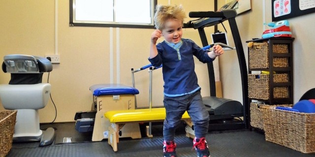 young boy learning to walk in the gym