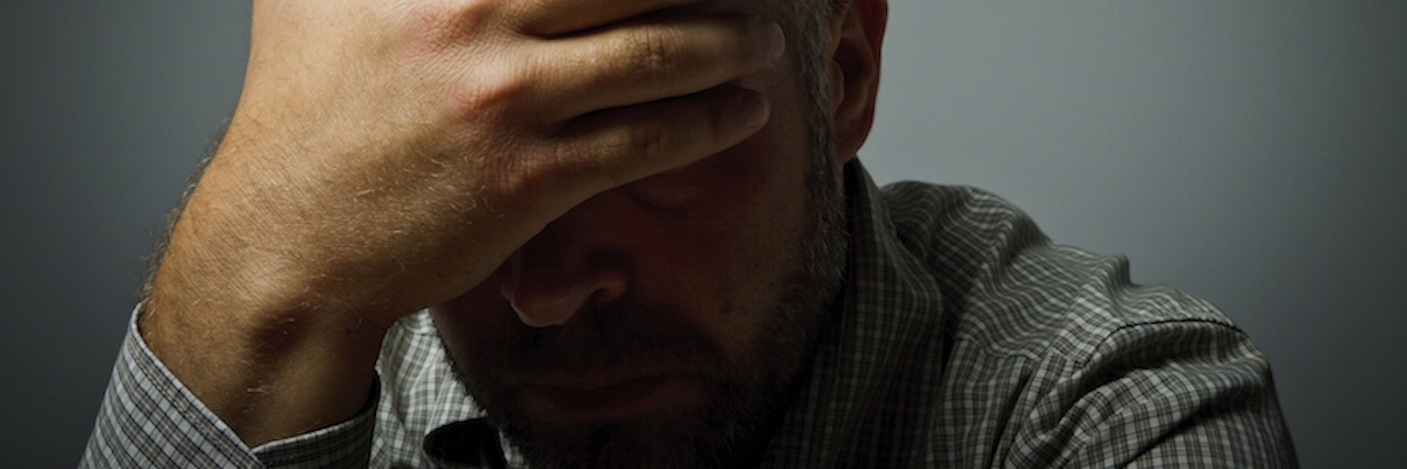 Helping Men With Depression and Suicidal Thoughts man resting head in hands