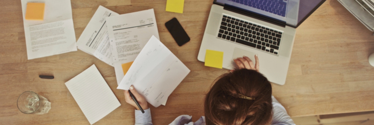 Balancing Work With My Chronic Illness Businesswoman working at her office desk with documents and laptop