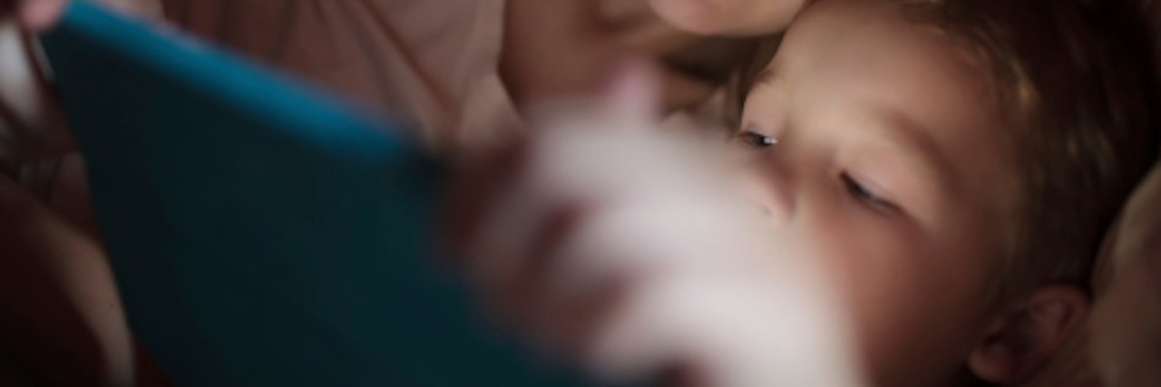 woman reading with child in bed