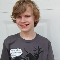 teenage boy with blonde hair and gray t-shirt