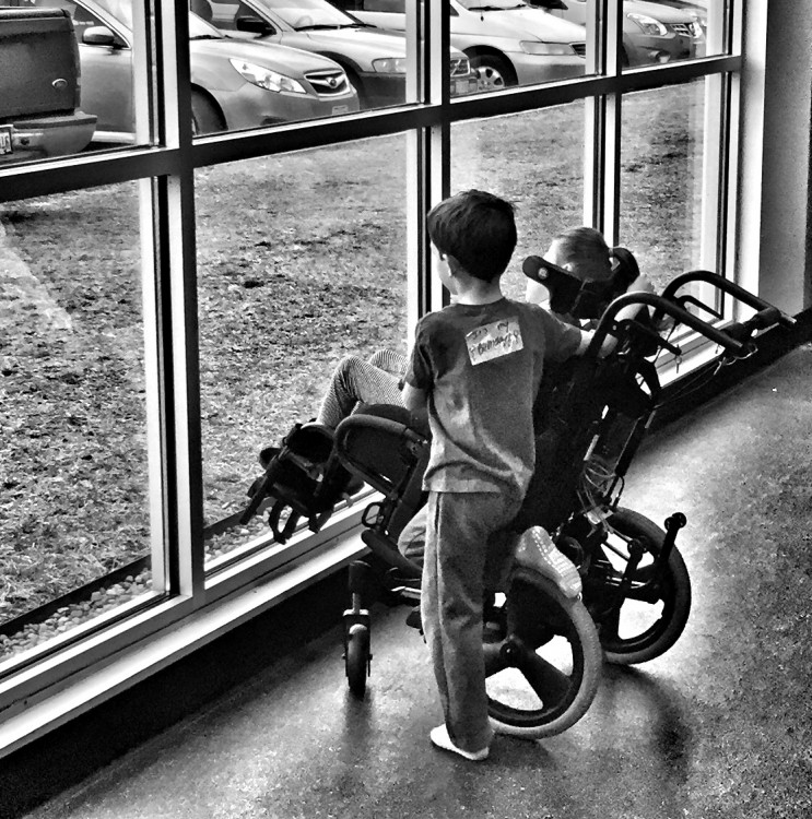 young boy and girl looking out large window