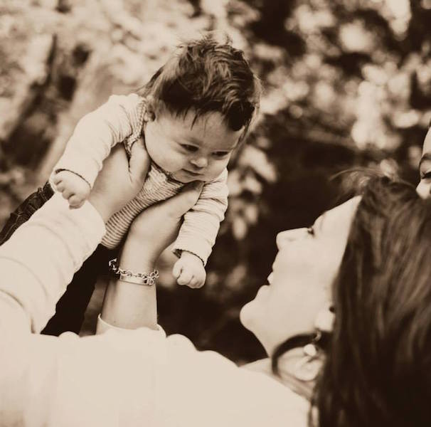 mother holding daughter in the air