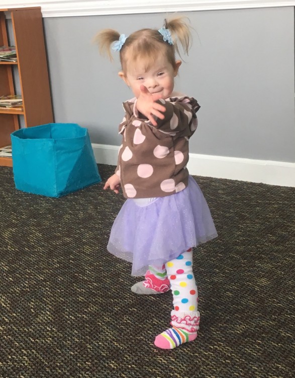 little girl with pigtails and purple tutu