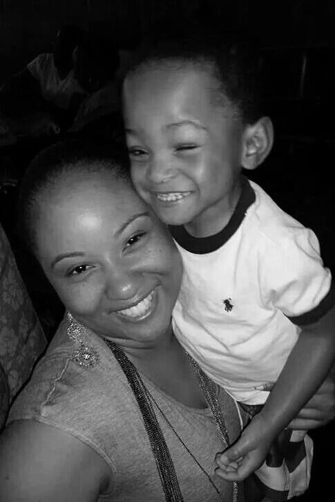 mom holding her smiling son in black and white photo