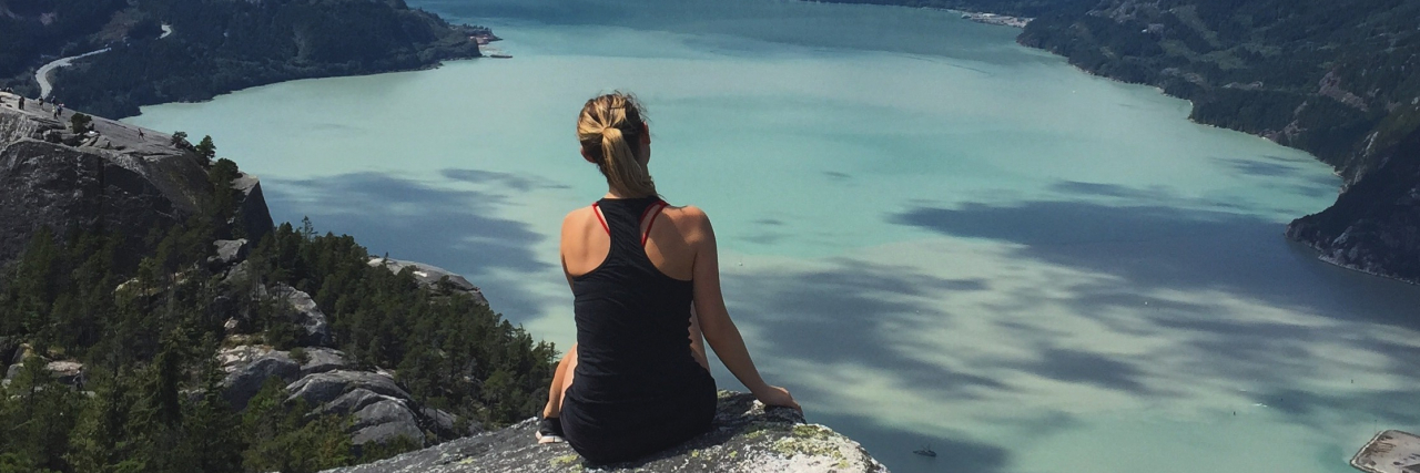 What I Should Have Told the Reporter Who Asked, ‘What Is Arthritis to You?' Woman sitting on rock looking at mountains and lake