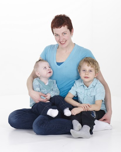 mom sitting on floor with baby girl and young boy