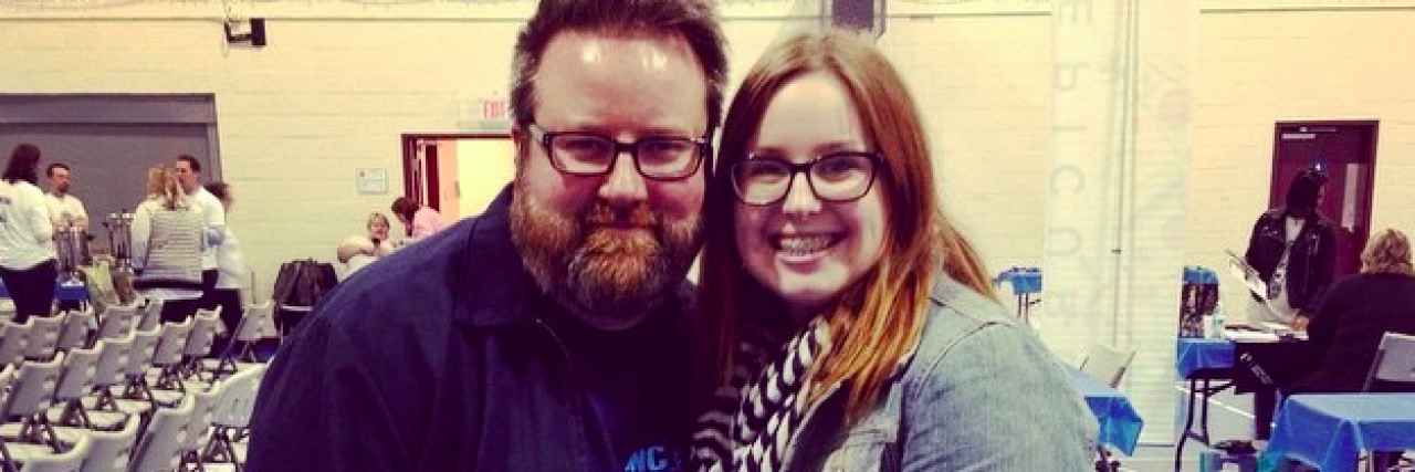 Why It's Important for Every Chronic Illness Story to Be Heard Woman and man smiling at event in school gym