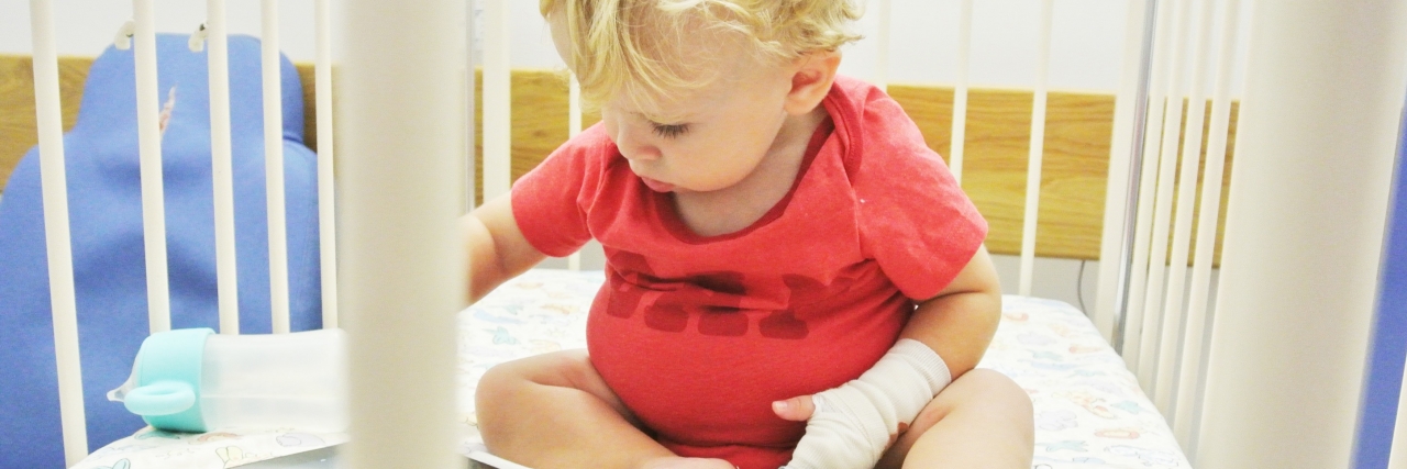 The Worries of a Mom of a Child With Prune Belly Syndrome boy playing with iPad in crib