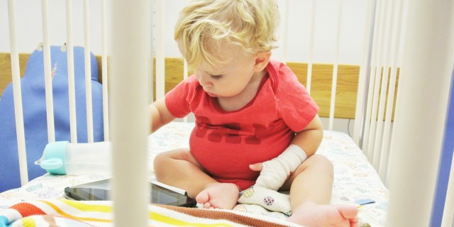 boy playing with iPad in crib