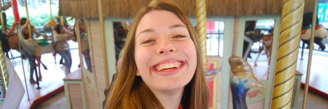 Naomi smiling on a merry-go-round