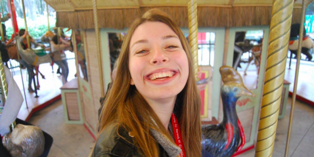 Naomi smiling on a merry-go-round