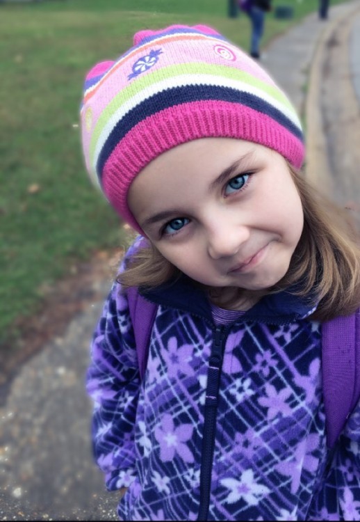 girl wearing pink striped beanie and purple jacket