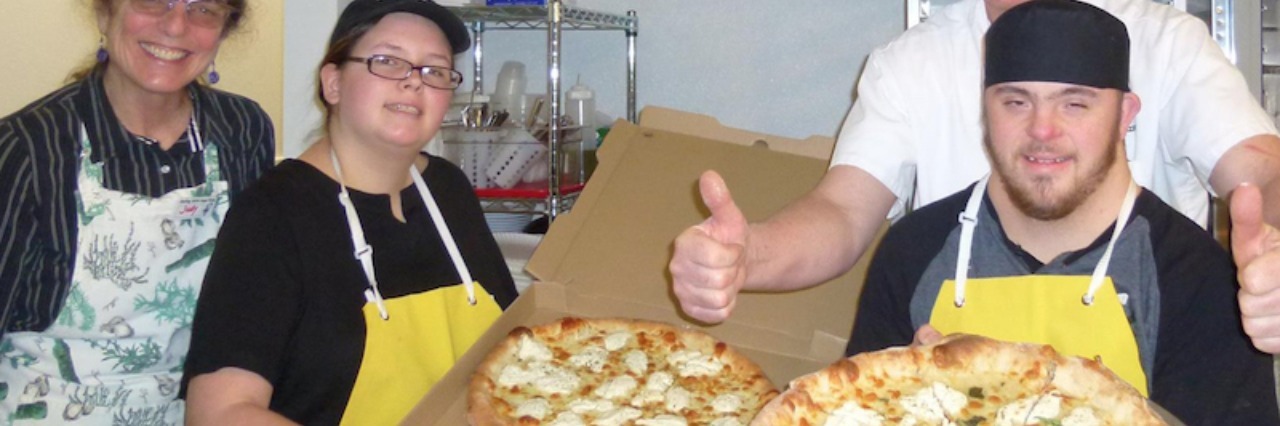 Couple Employs People With Disabilities at Smiling With Hope Pizza Workers at 'Smiling Hope Pizza' smile for camera as they hold pizzas