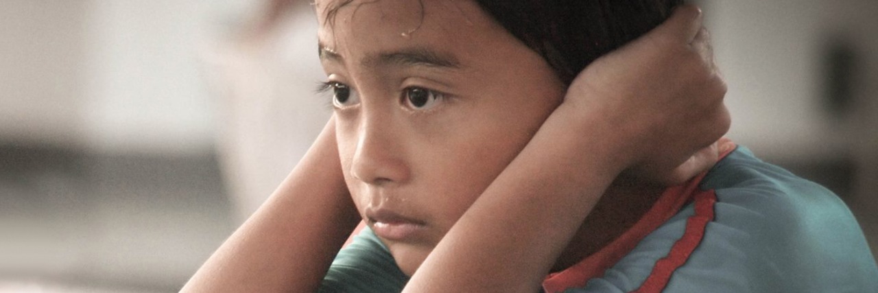 'Redha,' Malaysian Movie About Autism, Set for April Release young girl squatting with hands on head
