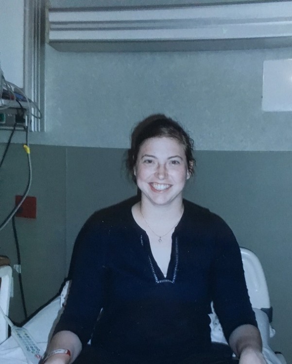 woman wearing blue shirt sitting on hospital bed
