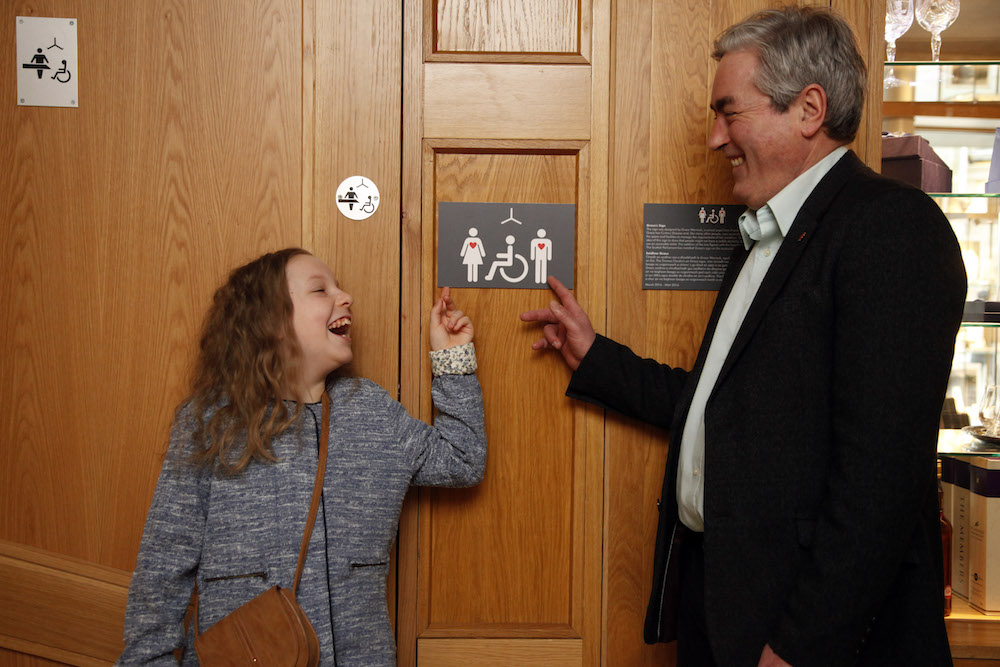 Iain Gray MSP and 10 year old Grace Warnock, a school pupil from Prestonpans in East Lothian, unveil a new disabled toilet signs, designed by Grace, which is now in place at the Scottish Parliament’s accessible toilets. 