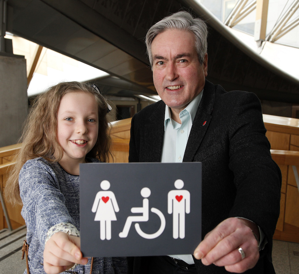 Iain Gray MSP and 10 year old Grace Warnock, a school pupil from Prestonpans in East Lothian, unveil a new disabled toilet signs, designed by Grace.