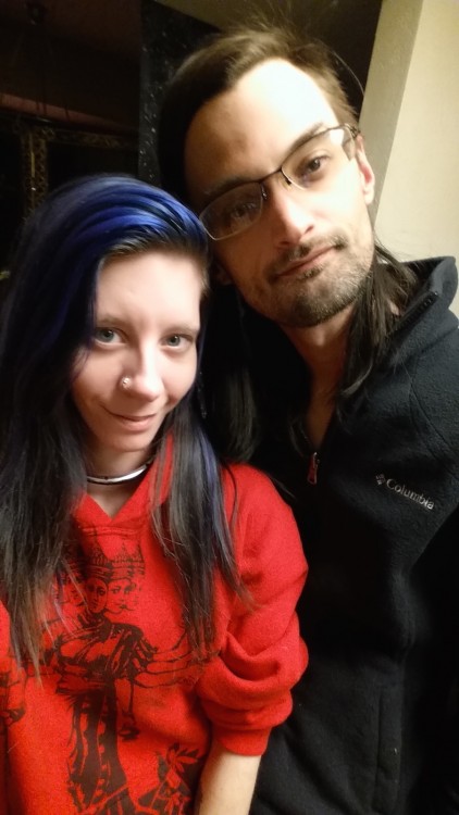 woman with purple hair standing next to her husband