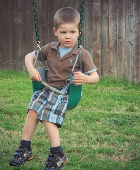 boy sitting in swing