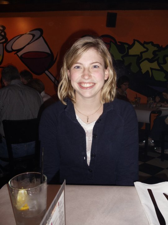 woman smiling sitting at tale in restaurant