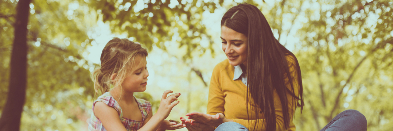 Explaining ADHD to My 7-Year-Old Daughter Mother and young daughter outside under tree