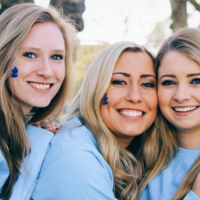 group of four girls dressed in light blue and paint representing autism awareness