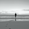 lone man standing next to the ocean