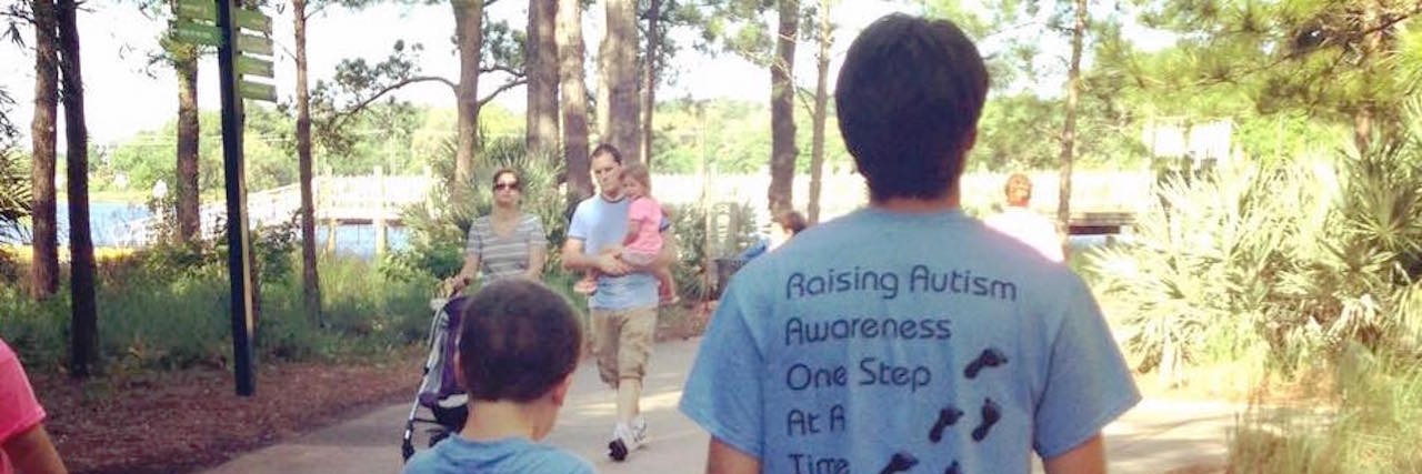 two brothers holding hands with autism shirts on