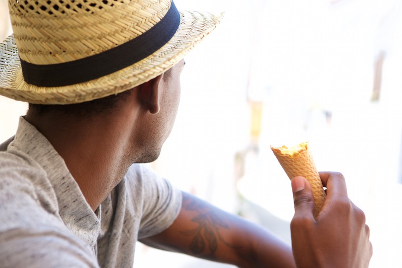 Young man with hat eating ice cream