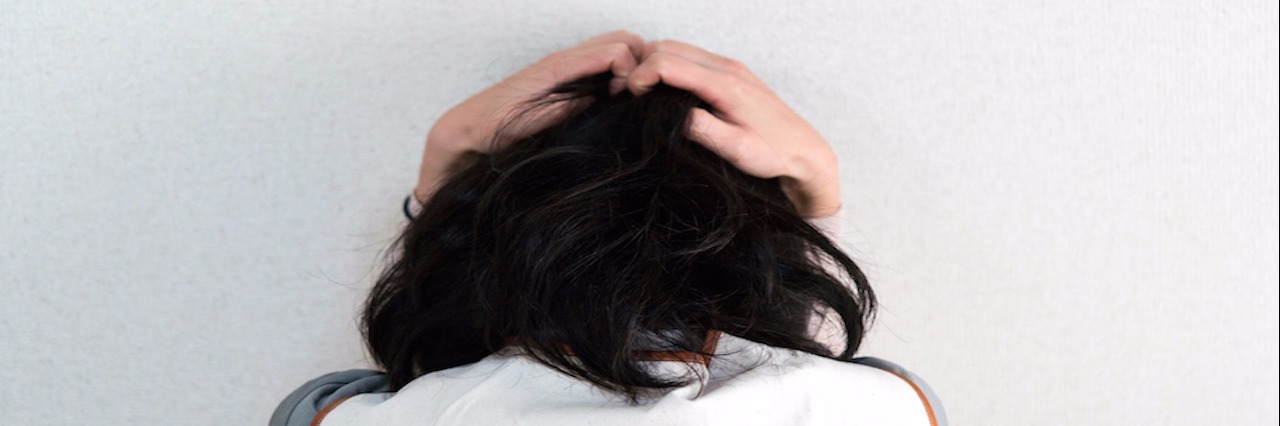 The 4 Phases of a Migraine woman holding head