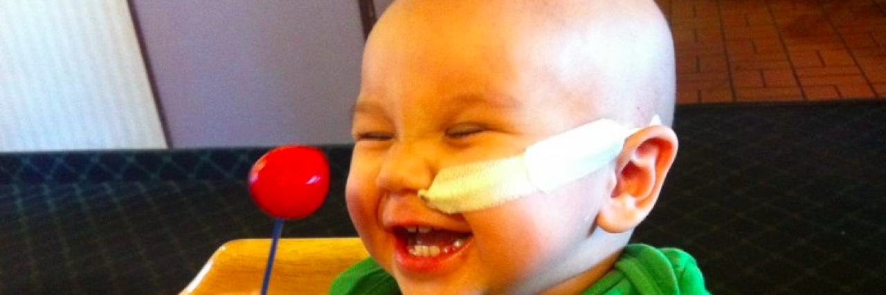 To the Superheroes in Scrubs I Didn’t Get to Thank While My Child Fought Cancer Baby with nose tube smiling while holding lollipop