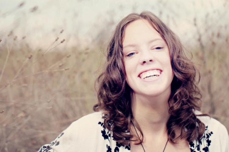 Amelia Coonrod - young woman with curly brown hair, smiling. 