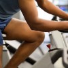 arms and legs of man using stationary bike at the gym