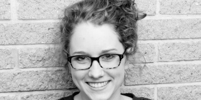 Black and white photo of contributor smiling and wearing glasses