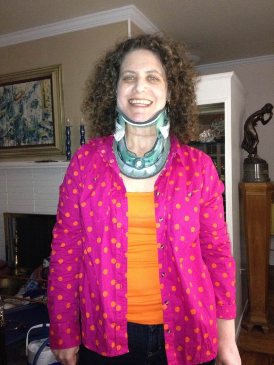 woman wearing neck brace and pink sweater with orange top