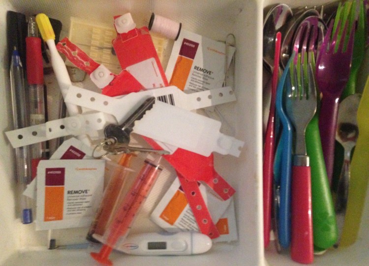 drawer with hospital bracelets on one side and spoons on the other