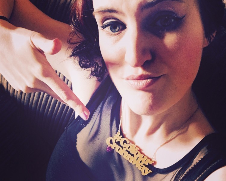 woman pointing to necklace that says Go Your Crohn Way