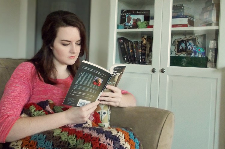 Liz sitting in a chair, reading a book