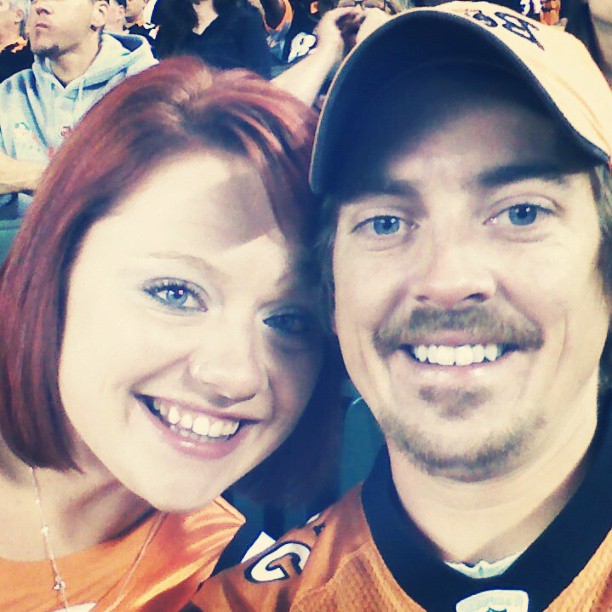 man and woman at game wearing orange jerseys