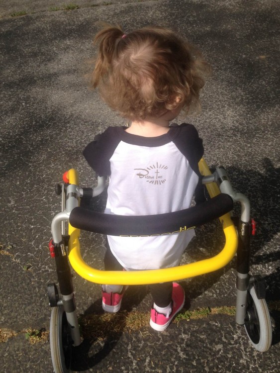 Alana's daughter with her yellow gait trainer and pink shoes