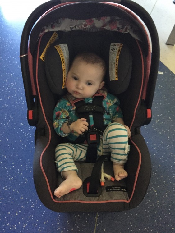 baby sitting in car seat on the floor