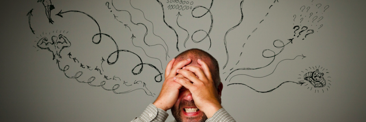 Man holding head in his hands with lines and thoughts drawn behind him