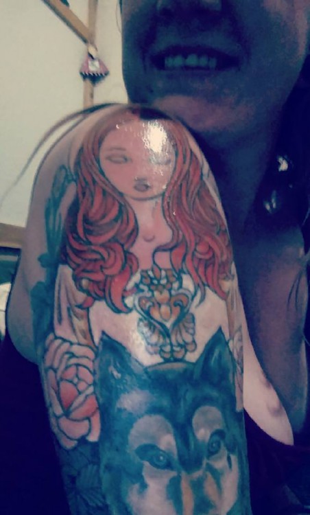 tattoo of red haired woman and wolf on arm