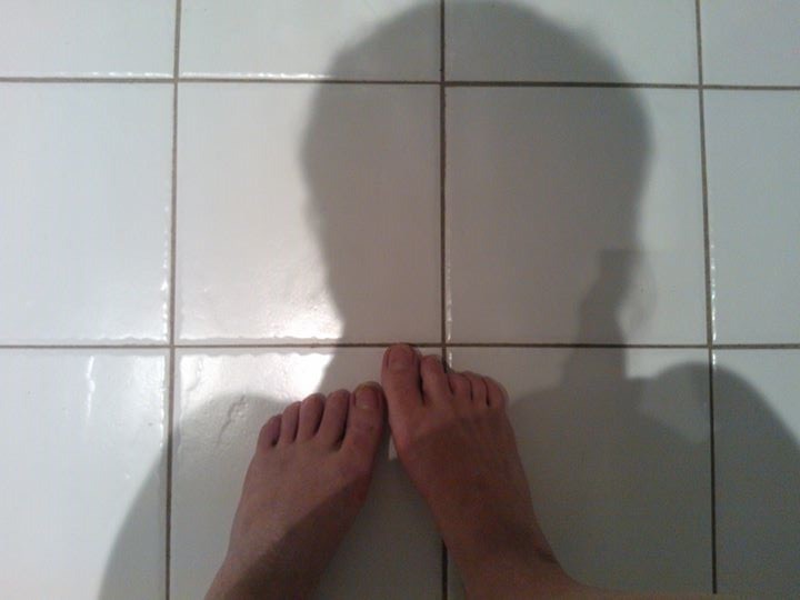 view of woman's feet on bathroom floor from above