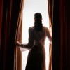 Woman staring through curtains